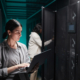 waist-up-portrait-female-data-engineer-using-laptop-server-room-while-setting-up-supercomputer-network-copy-space